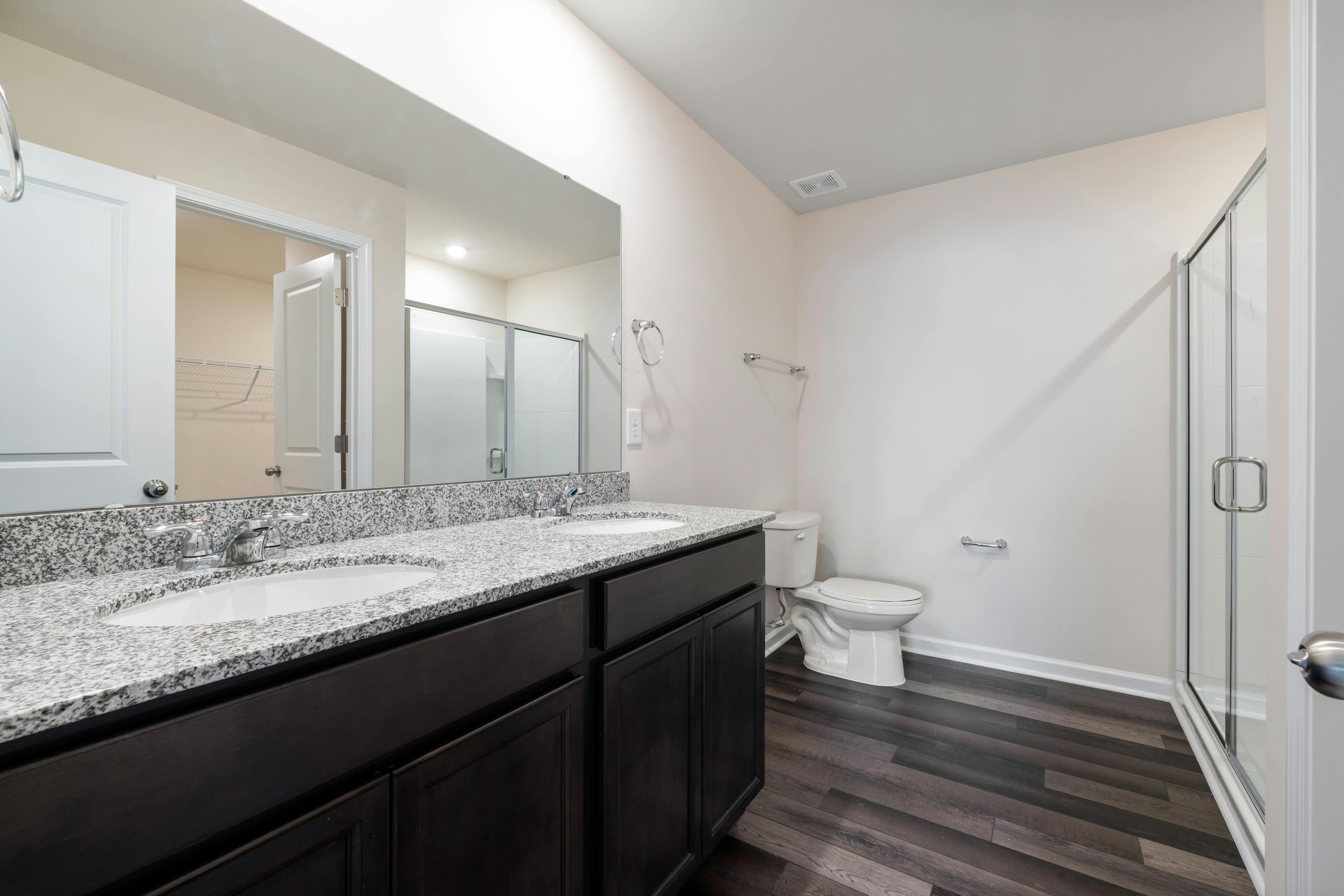 Home Elegant modern bathroom featuring granite countertops, glass shower, and hardwood floor for a sleek interior.